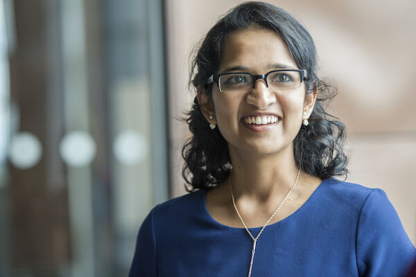 A woman wearing glasses looking past the camera