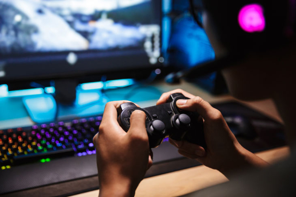 Hands holding a gaming system remote