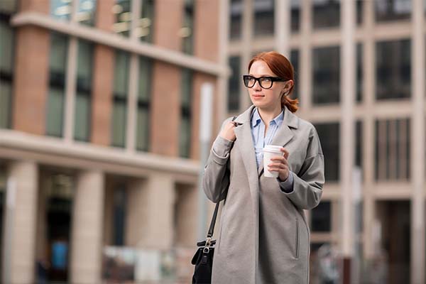 A woman holding a cup of coffee outdoors