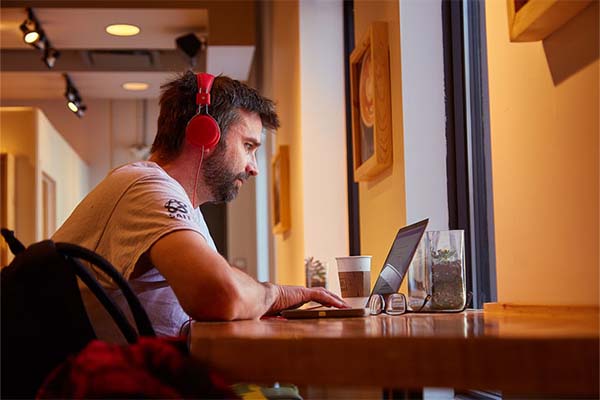 A student wearing headphones studies in a quiet place on campus.