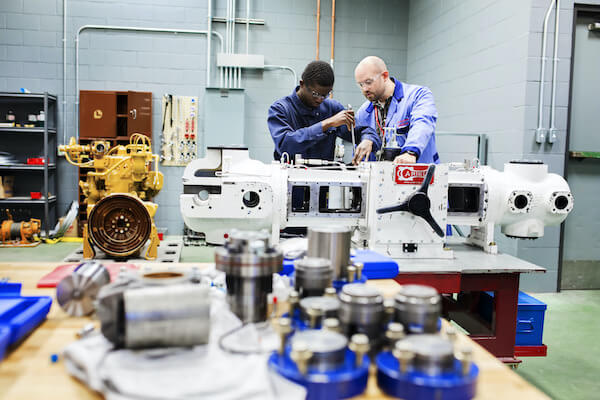 two people working on a motor