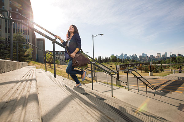 woman walks up SAIT's stairs