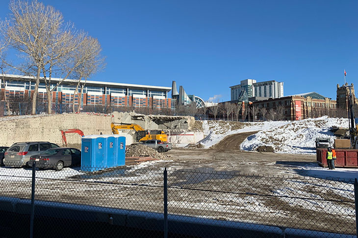 View of Campus Centre construction site from the CTrain platform. Heavy machinery pulling down building components