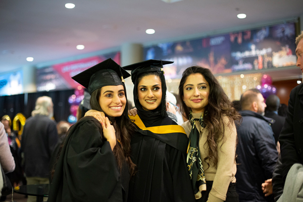 students in a graduation gowns standing together 
