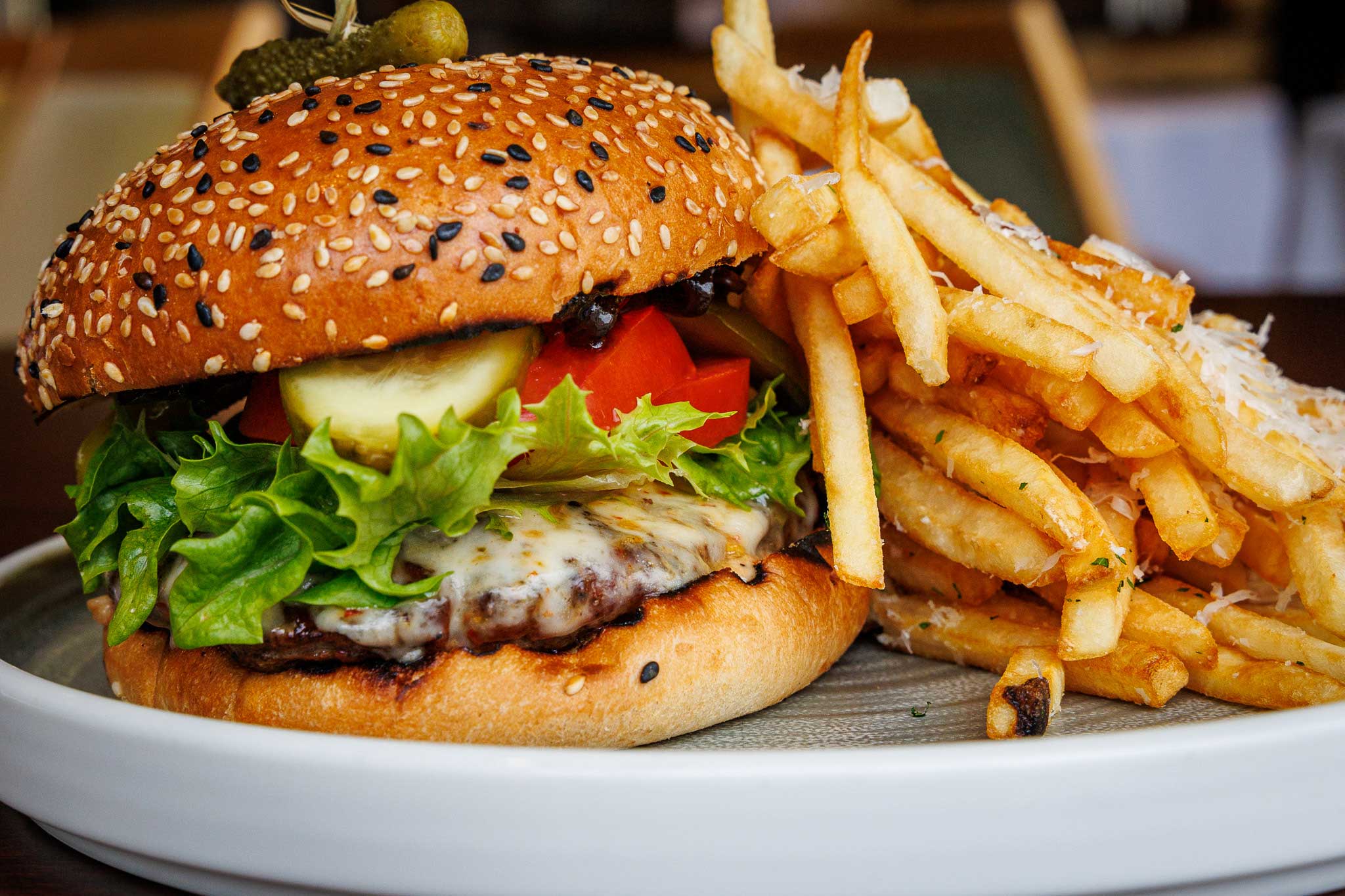 Highwood burger served on sesame bun with pepper jack cheese and a side of Highwood Bistro fries