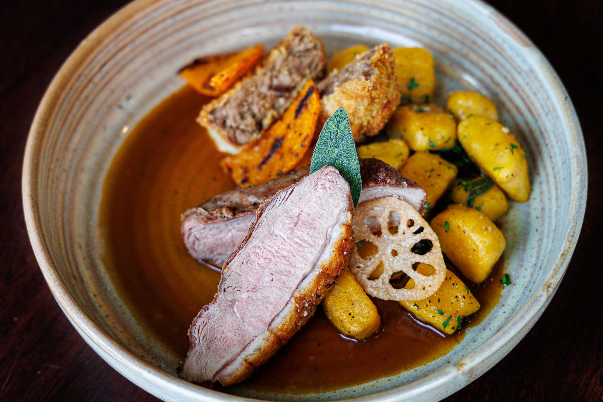 seared duck breast served with duck confit and roasted seasonal vegetables