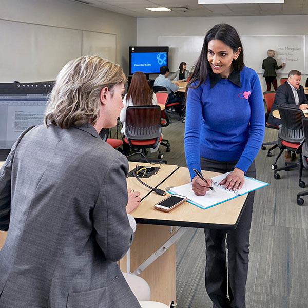 A young woman asks a SAIT instructor to review her work.