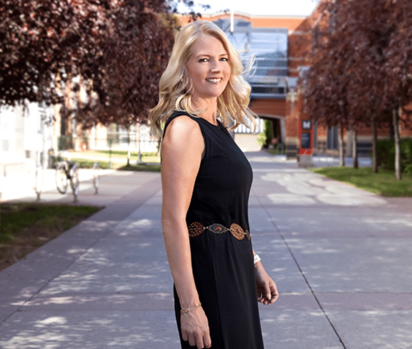 Linda Olsen turning over shoulder to look at camera wearing a black dress