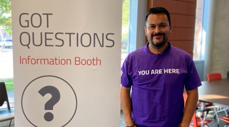 Man wearing a purple volunteer shirt smiling