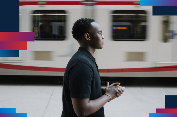 black man with hands together and train moving in background