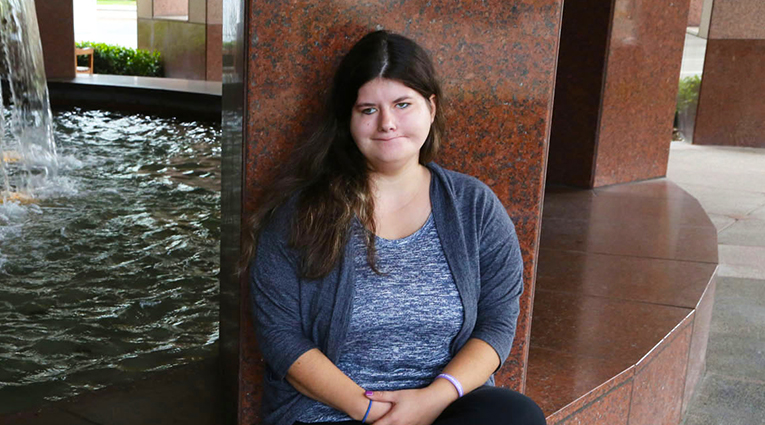 A person sitting beside a fountain indoors