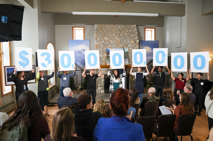 people holding up signs that read $30 million