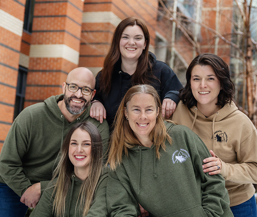 Group of students in hoodies smiling 