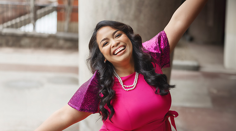Young Fillipina woman wearing bright pink smiling