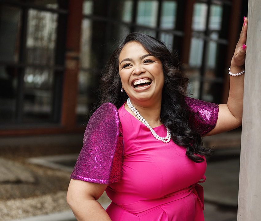 Young Fillipina woman wearing bright pink smiling