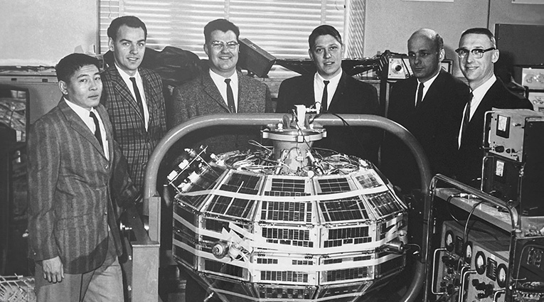 vintage photo of SAIT graduates around Alouette satellite
