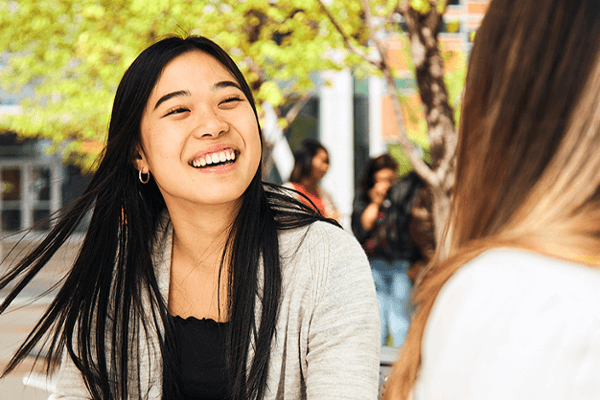 Two students in the English Conversation Partners program speaking to one another outside on SAIT campus.