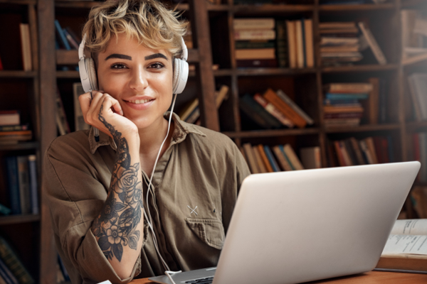 A woman wearing headphones with a laptop in front of her