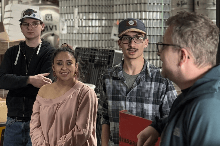Students at the Fahr brewery talk to staff members.